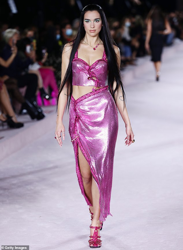 Shimmering: The busty two-piece dress featured a deep puce trim, with matching straps, and strapped heels in the same hue